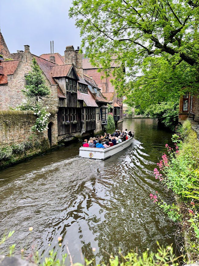 people in a boat doing a river tour in brugge belgium